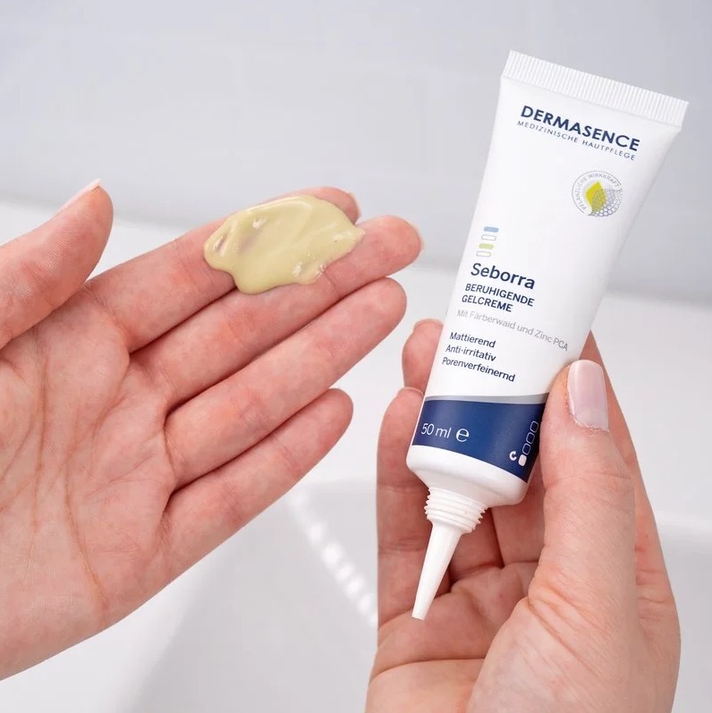 Een hand met een beetje lichtgroene gelcrème uit een tube DERMASENCE Seborra Soothing Gel Cream